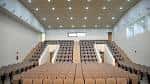 Interior del auditorio con gradas y butacas dispuestas para eventos culturales