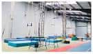 Interior del gimnasio de Aerial Edge Circus School con equipo de circo aéreo y colchonetas