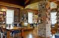 Interior del local con estanterías de libros, columnas de piedra y mesas para eventos