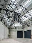 Interior del edificio mostrando la estructura metálica del techo y espacios amplios aptos para eventos