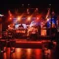 Escenario del local con iluminación en vivo y banda tocando