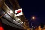 Vista nocturna exterior del local The Brick con su letrero iluminado