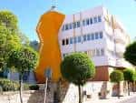 Vista exterior del Centro Cultural Pablo Neruda con su distintiva fachada naranja y edificio blanco