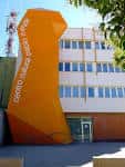 Detalle de la entrada principal con el nombre del centro en letras blancas sobre fondo naranja