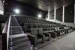 Interior de la sala de cine con butacas en gradas y pantalla grande