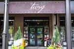 Fachada exterior de The Twig Book Shop con letrero y plantas decorativas
