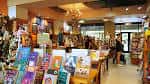 Interior acogedor de la librería con estanterías llenas de libros y clientes navegando
