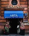 Fachada del local Artà en Glasgow con letrero azul y decoración floral