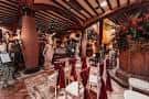 Interior del salón de eventos con mesas decoradas para boda y techo de vigas de madera