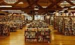 Interior de la librería con estanterías llenas de libros y techo de madera