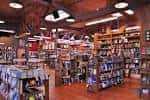 Vista del interior de la librería con iluminación cálida y múltiples pasillos de libros