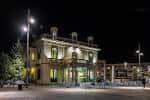 Fachada iluminada del edificio principal de la plaza durante la noche