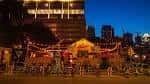 Atmósfera festiva en Rainey Street durante la noche con decoración iluminada y gente socializando