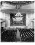 Interior del auditorio con escenario pintado y araña central