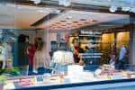 Vista del escaparate de la Óptica Samot con clientes y productos visibles