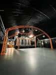 Espacio vacío con estructura arqueada y suelo pulido, ideal para eventos