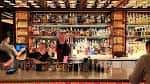 Interior del bar Jue Let con estanterías de botellas y ambiente acogedor