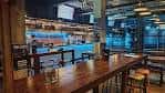 Interior del bar de Drygate con barra de madera y ambiente industrial