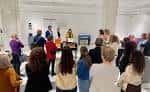 Evento cultural en curso con público reunido frente a un panel
