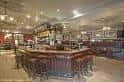 Interior del bar principal con barra de madera y ambiente acogedor
