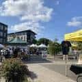 Escena exterior del Lents International Farmers Market con edificios y puestos en primer plano