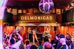 Escenario principal de Delmonicas con luces de neón y público celebrando