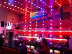 Interior del bar con iluminación roja y barra iluminada