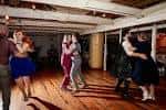 Boda al atardecer en el interior del barco con parejas bailando