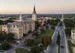 Vista aérea del campus universitario con edificios históricos y torres góticas