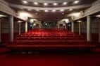 Interior del auditorio con butacas rojas y escenario