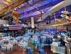 Salón de eventos del museo con mesas dispuestas para recepción y decoración temática aérea