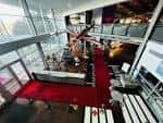 Vista panorámica del interior del museo con alfombra roja y exhibiciones aéreas en niveles superiores