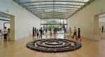 Interior del museo con gran instalación artística circular y visitantes