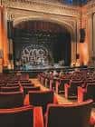 Interior del auditorio del Lyric Stage mostrando butacas rojas y vista al escenario
