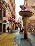 Calle San Francisco en Alicante con escultura de seta gigante y ambiente peatonal