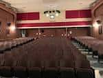 Interior del auditorio con butacas rojas y escenario