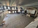 Interior del salón en proceso de renovación, mostrando la estructura y el espacio amplio