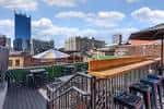 Vista panorámica de la terraza superior del Tin Roof con mobiliario y vistas a los rascacielos de Nashville