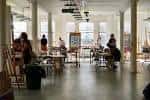 Interior del centro de arte KCAT con artistas trabajando en un espacio amplio y luminoso