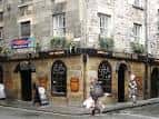 Vista exterior de Bannerman's en Edimburgo, pub tradicional con fachada de piedra y letrero de CAMRA