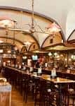 Interior del restaurante con barra larga y arcos decorativos