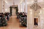 Ceremonia de boda en el Minneapolis Club, decorada con arcos florales y candelabros elegantes