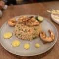 Camarones dorados sobre arroz frito con toques de limón