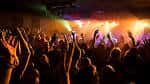 Público disfrutando de un concierto en vivo con luces de colores