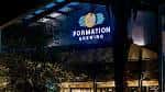 Fachada iluminada de Formation Brewing por la noche con letrero visible