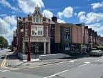 Vista exterior del Hyde Park Picture House en Leeds con fachada histórica y cielo azul