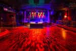 Escenario principal del Smith's Olde Bar con iluminación de colores vibrantes y pista de baile vacía