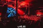 Interior del club con iluminación roja y pantalla de DJ en vivo