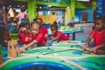 Niños participando activamente en una actividad educativa en el área de construcción del museo