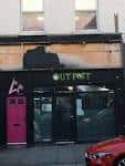 Fachada exterior del local Outpost en Liverpool con letrero iluminado